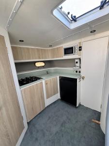 an rv kitchen with a stove and a microwave at Boat with Jacuzzi - Bateau avec Jacuzzi in Mandelieu-la-Napoule +21 photos