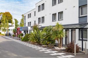 an empty street in front of a white building at Hôtel AKENA Nantes Orvault - Ouest in Orvault