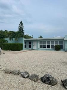 una casa con rocas delante de ella en Comfortable, Spacious 3-BR, 2-BA-1 level home- DEEP dock on canal, Islamorada, en Islamorada