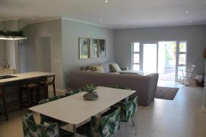 een woonkamer met een bank en een tafel bij Goodholme Guesthouse - Modern Spacious Peaceful in Durban
