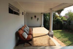 een woonkamer met een bank op een patio bij Goodholme Guesthouse - Modern Spacious Peaceful in Durban