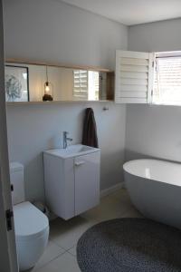 een badkamer met een bad, een toilet en een wastafel bij Goodholme Guesthouse - Modern Spacious Peaceful in Durban