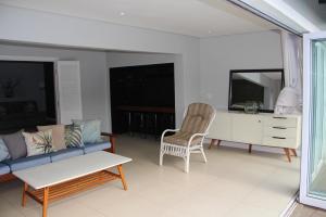 een woonkamer met een bank en een stoel bij Goodholme Guesthouse - Modern Spacious Peaceful in Durban