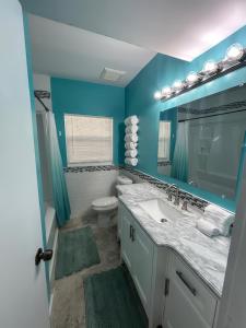 Un baño con lavabo, inodoro y espejo. en Comfortable, Spacious 3-BR, 2-BA-1 level home- DEEP dock on canal, Islamorada, en Islamorada 16 fotos más