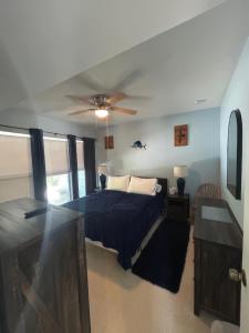 Un dormitorio con una cama y un ventilador de techo. en Comfortable, Spacious 3-BR, 2-BA-1 level home- DEEP dock on canal, Islamorada, en Islamorada