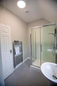 een badkamer met een glazen douche en een wastafel bij Stanmore House - Winchester  +32 foto's