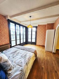 a bedroom with a bed in a room with windows at Appartement lumineux 50M2 proche mer-centre Portel in Le Portel