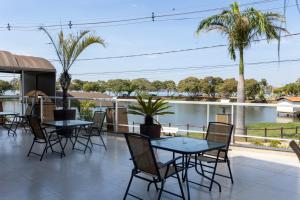 Un patio con mesas y sillas y vista al agua. en JHS Palace Hotel, en Boa Esperança