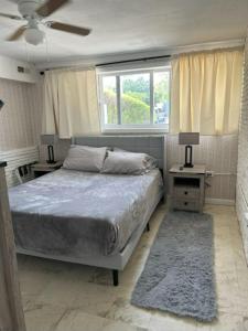 1 dormitorio con 1 cama, 2 mesas y una ventana en Comfortable, Spacious 3-BR, 2-BA-1 level home- DEEP dock on canal, Islamorada, en Islamorada