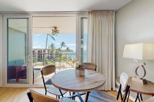 a living room with a table and chairs and a balcony at Hale Ono Loa 406 in Honokowai