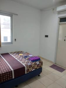 Un dormitorio con una cama en una habitación con ventana. en sa'ci guest house, en Bandung