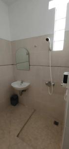 Un baño con lavabo y ducha con espejo. en sa'ci guest house, en Bandung