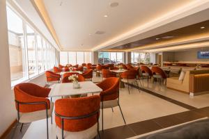 a restaurant with tables and chairs and windows at Hotel Presidente Huancayo - Asociado Casa Andina in Huancayo