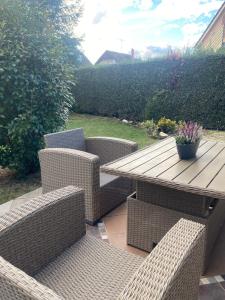 ein Holztisch und Korbstühle und ein Holztisch in der Unterkunft Erelia Cottage in Bük