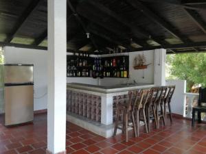 a bar with stools and a counter with alcohol at Finca Campestre Foundation Ecopiensa Evolution in Andalucía