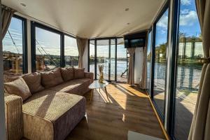 a living room with a couch and a view of the water at Houseboat Toruń in Toruń