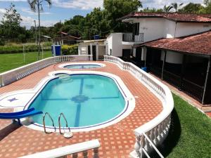 a swimming pool with a brick patio and a house at Finca Campestre Foundation Ecopiensa Evolution in Andalucía +45 photos