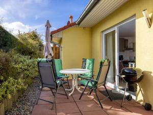 a patio with a table and chairs and an umbrella at Windflüchter XL in Boiensdorf