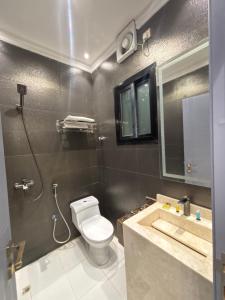 a bathroom with a toilet and a sink and a shower at شركة سعادات الانماء-دار الطائف سويتس in Quai +22 photos