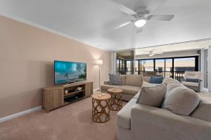 a living room with a couch and a flat screen tv at Kings Crown 309 in Sanibel
