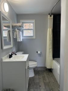a bathroom with a sink and a toilet and a window at Chaplin Inn & Suites in Chaplin