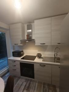 Una cocina con gabinetes blancos y un fregadero. en Callisto, en Dervio