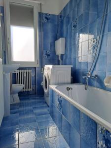 a blue bathroom with a tub and a toilet at B&B Sabry in Casalecchio di Reno +10 photos
