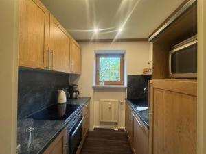 een keuken met houten kasten en een zwart aanrechtblad bij ciao-aschau Grenzhub FeWo 206 Puhlmann in Aschau