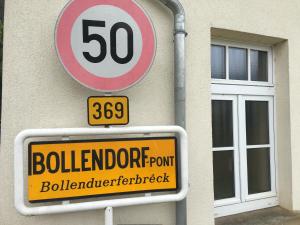 een snelheidsbegrenzingsteken aan de zijkant van een gebouw bij 25 Bollendorf in Bollendorf-Pont