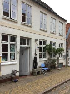 a white house with a blue chair in front of it at westcoast-Speicher in Friedrichstadt