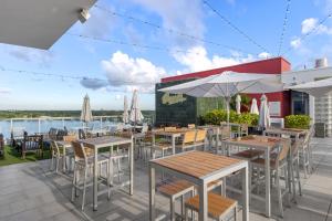 an outdoor patio with tables and chairs and umbrellas at Luxury Condo with Serene Balcony View in Hollywood