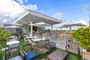an outdoor patio with tables and chairs and umbrellas at Luxury Condo with Serene Balcony View in Hollywood