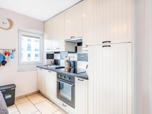a kitchen with white cabinets and a stove at Vicky derde in Galopen