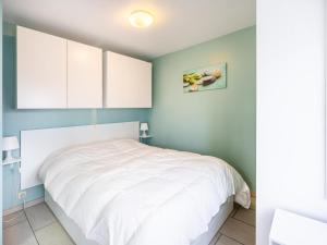 a bedroom with a white bed and blue walls at Vicky derde in Galopen