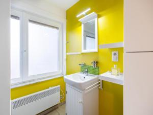 a yellow bathroom with a sink and a window at Vicky derde in Galopen +7 photos