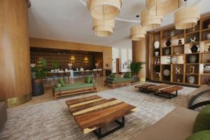 a lobby with a library with green chairs and tables at Hotel Mundo Maya Chichén Itzá in Chichén-Itzá +79 photos