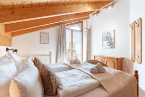 a bedroom with a bed with white sheets and pillows at Landhaus Christine in Oberstdorf