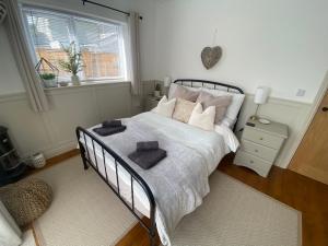 a bedroom with a bed with two towels on it at Tŷ Twt in Pontardawe