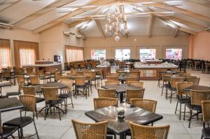 奥林匹亚Thermas de Olimpia Resort的餐厅里有桌椅和吊灯