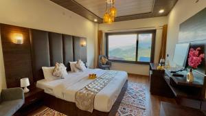 a hotel room with a large bed and a desk at Leela Huts - Best Selling Hotel In Dalhousie in Dalhousie