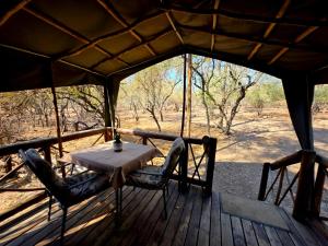 a table and chairs sitting on a porch of aentedentedentedentedentedented at Kruger Dreams Lodge in Marloth Park