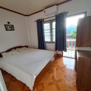 Un dormitorio con una cama y una ventana grande. en vangvieng SCK Hotel, en Vang Vieng