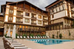 a hotel with a swimming pool in front of a building at Appartement moderne et chic Ski & Spa Bansko in Bansko