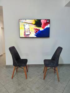 two chairs in a room with a tv on a wall at Le paradis in Martil +8 photos
