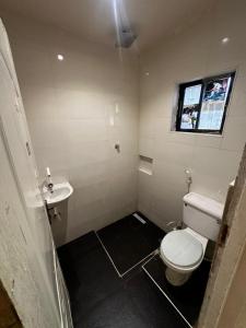 a bathroom with a white toilet and a sink at One Bedroom Studio Apartment in Benin City