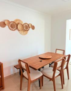 a dining room table with chairs and hats on the wall at Lar e Mar PG in Praia Grande +20 photos