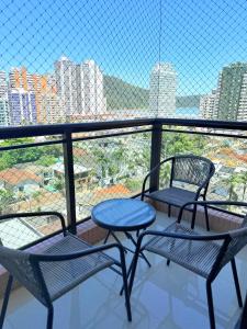 two chairs and a table on a balcony with a view at Lar e Mar PG in Praia Grande