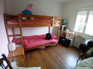 Un dormitorio con dos literas con un perro en una cama. en maison en banlieue de Caen, en Sept-vents 3 fotos más