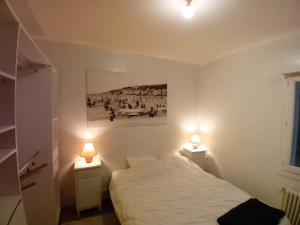 Un dormitorio con una cama y dos luces en dos mesitas de noche. en maison en banlieue de Caen, en Sept-vents