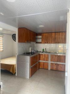 a kitchen with wooden cabinets and a bed in a room at La bendición de sunnyvale in La Vega